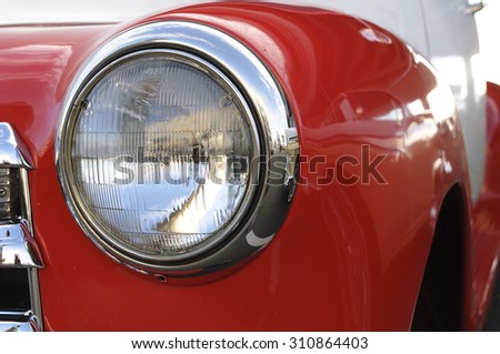 Fancy headlight of a vintage red car