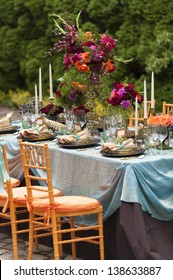 Fancy outdoor event table and plate setting with various flowers.