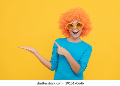 fancy party look. kid in clown wig presenting product. funny child with fancy hair. cheerful teen girl wear party glasses. just having fun. april fools day. happy childhood. going crazy. copy space.