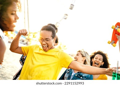 Fancy party makers dancing at sunset concert on summer day - Trendy life style concept with guys and girls having genuine fun together at spring break festival - Bright vivid filter with sunshine halo