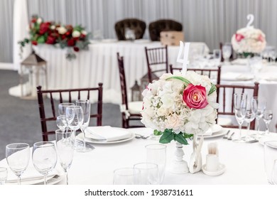 Fancy Table Set For Dinner With Flower Composition In Restaurant, Luxury Interior Background. Wedding Elegant Banquet Decoration And Items For Food Arranged By Catering Service On White Table