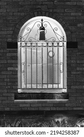 Fancy Vintage Iron Grating On A Huge Arched Window In A Black And White Monochrome Film Negative.