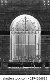 Fancy Vintage Iron Grating On A Huge Arched Window In A Black And White Monochrome Film Negative.