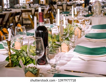 A fancy wedding table setup with wine and glasses.
