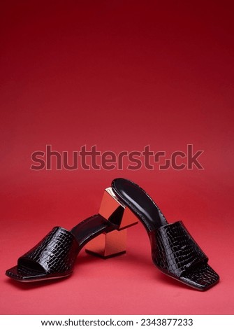Fancy women's black open-toe flip-flops. Crocodile leather texture and golden metallic heels, isolated on a gradient pink background with a copy space. A modern and fashionable shoe store.