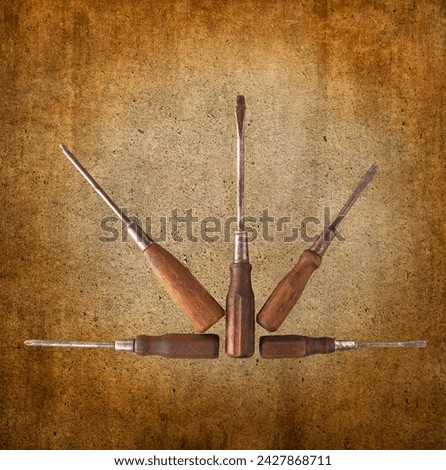 A fan-like array of five old phillips and straight blade wooden handle screw drivers showing the proud patina of many decades of use.