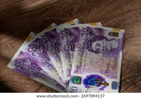 Fanned stack of 20 GBP notes on table. Cash and money concept for finance, personal savings, and stock photography.