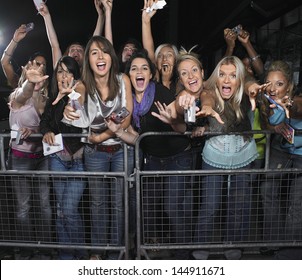 Fans leaning over barrier and screaming