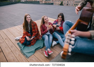 Fans On Live Music Show. Friends Leisure. Girls With Fast Food In Hands Listen Singer's Acoustic Guitar Improvisation.