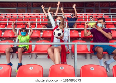 Fans Watching Football Match Under Social Distancing Measures In Stadium Wearing Masks