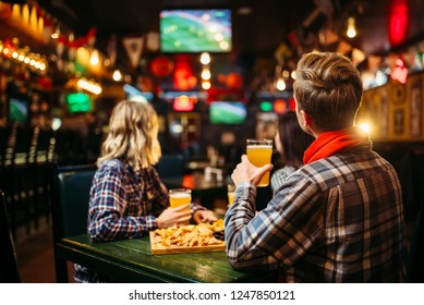 Fans Watching Match And Drinks Beer In Sports Bar