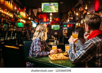 Fans Watching Match And Drinks Beer In Sports Bar