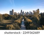Fantastic Chicago skyline aerial drone photograph above Lincoln Park with a tree lined walkway centered on a sunny blue sky autumn day.