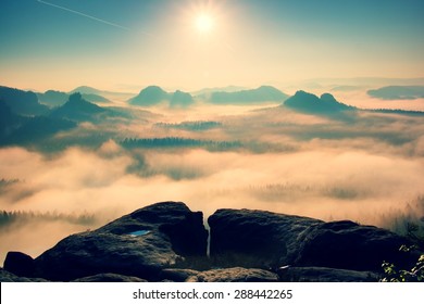 Fantastic dreamy sunrise on top of rocky mountain with view into misty valley.Mountain view.Foggy mountain.Dreamy forrest. Sunrise clouds. Forest hill.Autumn mist.Misty peaks.Foggy landscape. Hill top