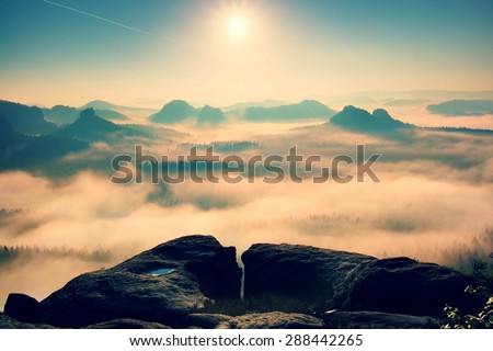 Fantastic dreamy sunrise on top of rocky mountain with view into misty valley.Mountain view.Foggy mountain.Dreamy forrest. Sunrise clouds. Forest hill.Autumn mist.Misty peaks.Foggy landscape. Hill top
