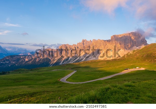 fantastic mountain scenery. colorful clouds\
in the sky. over the glowing in sunlight mountain peak. with\
serpentine road. nature\
background.