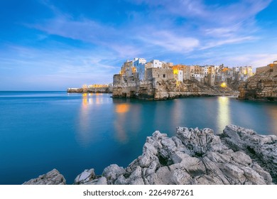 Fantastic night scene at Cala Paura gulf with Bastione di Santo Stefano in village on the rocks Polignano a Mare, Apulia, Italy, province of Bari. - Powered by Shutterstock