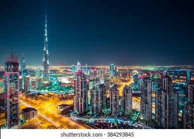 Fantastic nighttime skyline with illuminated skyscrapers. Rooftop perspective of downtown Dubai, UAE. 