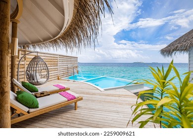 Fantastic over water villa, terrace view with sun beds chairs under umbrella, luxury pool hotel with stunning ocean view. Beautiful spa or wellness concept, recreational vacation resort tranquil area
