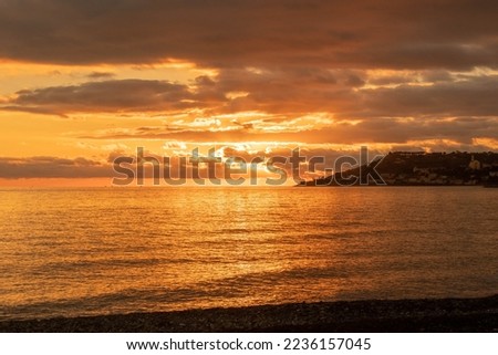 a fantastic red sunset over the Ligurian Sea in the province of Imperia. Italy. Sky and sea are mirrored. December 2022