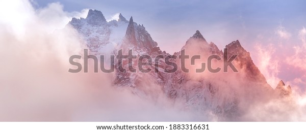 Fantastic snow mountains landscape banner\
background. Colorful pink and blue clouds overcast sky. French\
Alps, Chamonix Mont-Blanc,\
France