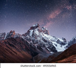 Fantastic starry sky. Autumn landscape and snow-capped peaks. Main Caucasian Ridge. Mountain View from Mount Ushba Meyer, Georgia. Europe. - Powered by Shutterstock