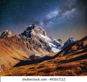 Fantastic starry sky. Autumn landscape and snow-capped peaks. Main Caucasian Ridge. Mountain View from Mount Ushba Meyer, Georgia. Europe. - Powered by Shutterstock