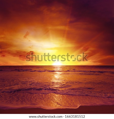 Fantastic sunset over ocean, sea waves and sand.