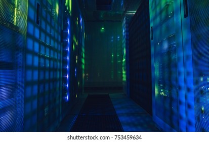 Fantastic view of the mainframe in the data center rows. Shot of a corridor in large working data center full of rack servers and supercomputers. Data centre interface.