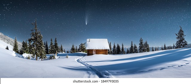 Fantastic winter landscape panorama with wooden house in snowy mountains. Starry sky with Milky Way and snow covered hut. Christmas holiday and winter vacations concept