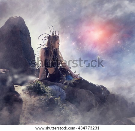 Fantastic woman. Woman witch sitting on a large stone on a background of sunset sky, fog and stars make magic. Magic planet. Fantasy world.