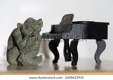 The fantastical gnome sits brooding next to a model piano