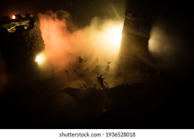 Fantasy battle scene with dragons attacking a medieval castle at night. Battle between dragon and heroic soldiers. Creative table decoration. Selective focus