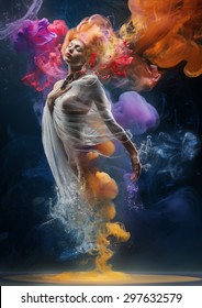 Fantasy fashion model inside colorful clouds. Water paint spreading underwater. Fantastic shapes in deep space.
