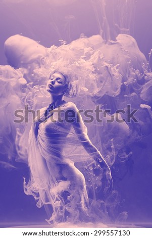 Fantasy fashion model inside ultraviolet clouds. Paint spreading underwater. Abstract shapes in space.