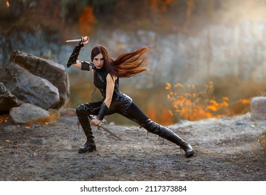 Fantasy fighting woman assassin actions in motion battle, hold daggers in hand. Red-haired girl warrior in black leather costume. ninja soldier with knives. Red long hair fluttering fly in wind.