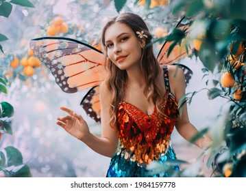 Fantasy Happy Woman Fairy Walks In Jungle. Happy Girl In Carnival Costume Bright Orange Monarch Butterfly Wings. Red Shiny Dress. Background Garden Lemons Fruits Green Tree Mystical Fog. Smiling Face.