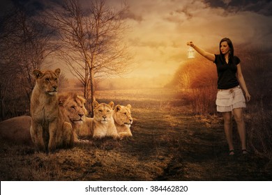 Fantasy image of a woman with lamp walking between lions.