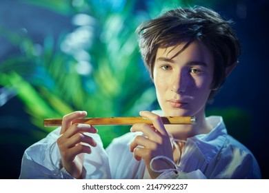 Fantasy. Portrait Of An Elf Boy Playing His Flute In The Magic Forest. Fairy Tale, Magic.