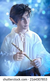 Fantasy. Portrait Of An Elf Boy Standing In The Magic Forest With A Flute In His Hands. Fairy Tale, Magic.