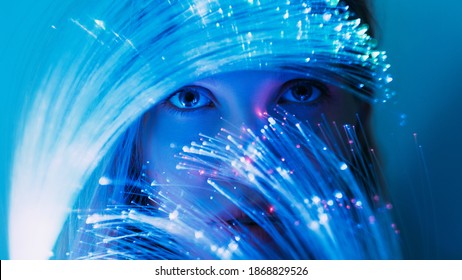 Fantasy portrait. Inner world. Fairytale mystery. Magic miracle. Curious female face with expressive eyes looking through optical fiber blue pink fluorescent neon light.