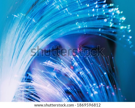 Fantasy portrait. Magic dream. Imagination subconscious. Mind harmony. Peaceful woman face with closed eyes behind optical fiber blue pink fluorescent neon light.