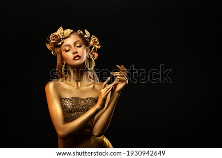 Fantasy portrait of woman, golden skin body. Girl goddess in wreath, gold roses, dress. Beautiful face steel glitter art makeup. Artistic photo dark black background. Girl princess. Fashion model pose