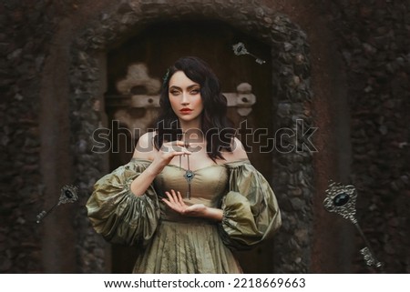 Fantasy portrait woman princess keeps secret holds old key to all doors in hands. Background old wall, wooden door. Medieval Girl Vintage Golden Ancient Style Dress. keys fall hovering floating in air
