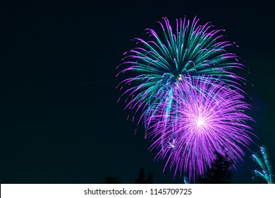 Fantasy Purple And Green Fireworks Display On Dark Sky Background; Celebrations, Festivals, Independence Day, 4th Of July Or New Year