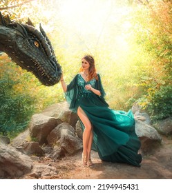 Fantasy Woman Queen, Hand Touches Muzzle Of Ancient Dragon. Green Vintage Silk Dress Fabric Skirt Fly In Wind Naked Sexy Legs. Golden Crown. Girl Princess Zodiac Sign Dragon. Nature Summer Trees