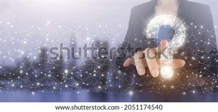 FAQ frequently asked questions concept. Hand touch digital screen hologram question mark sign on city light blurred background. Business support concept. Problems and solutions