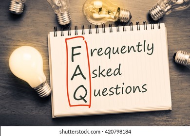 FAQ ( frequently asked questions ) text on notebook with many light bulbs