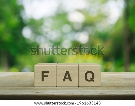 FAQ letter on block cubes on wooden table over blur green tree in park, Frequently asked questions, Business customer service and support concept