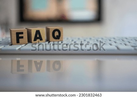 FAQ message on the wooden cube placed on the keyboard. Acronym faq of frequently asked questions